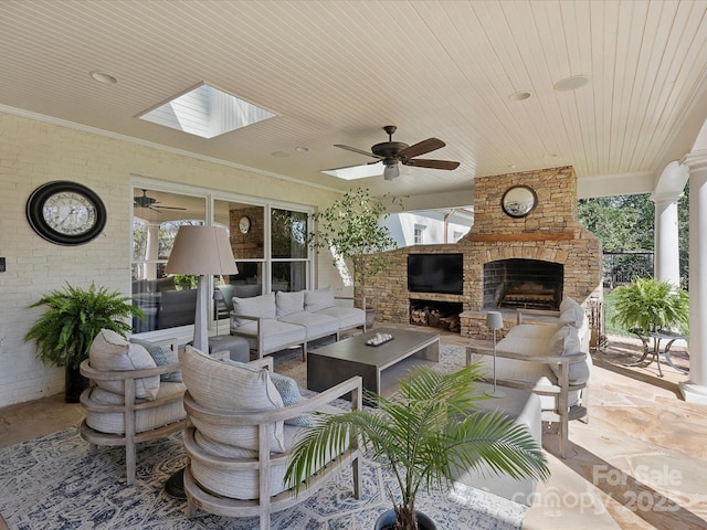 exterior space with an outdoor living space with a fireplace and a ceiling fan