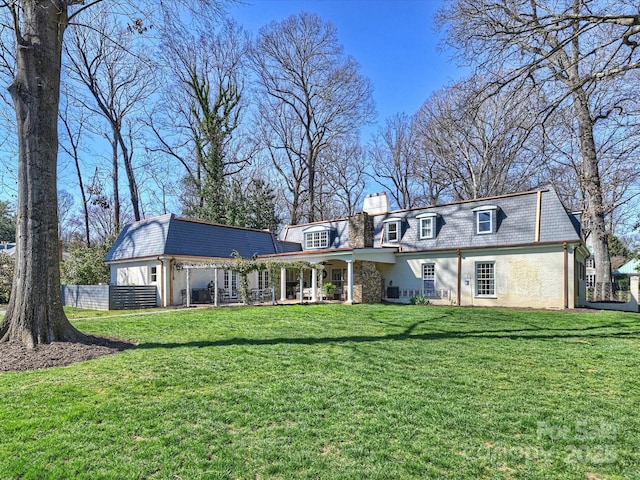 view of front facade featuring a high end roof, fence, a chimney, and a front lawn