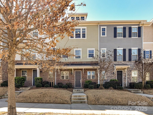 townhome / multi-family property featuring brick siding