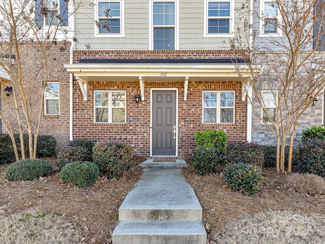 doorway to property featuring brick siding