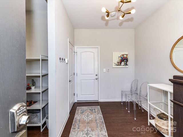 foyer featuring an inviting chandelier, baseboards, and wood finished floors