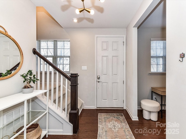 foyer with stairway, wood finished floors, and baseboards