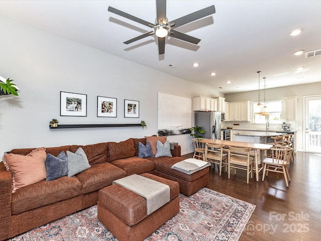 living area with ceiling fan, visible vents, dark wood finished floors, and recessed lighting