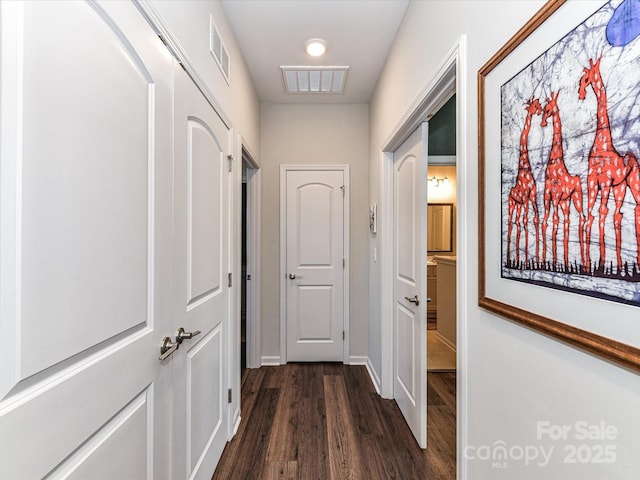 hallway with dark wood-style floors and visible vents