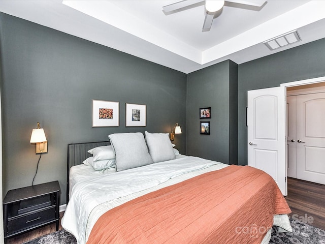 bedroom featuring a ceiling fan, visible vents, and wood finished floors