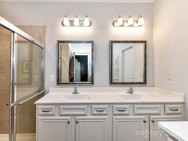 bathroom with a sink, a shower stall, and double vanity