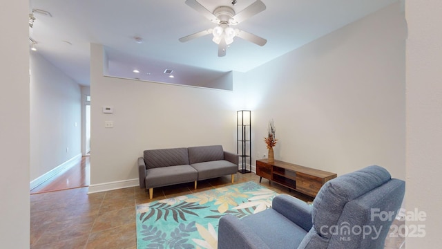 living area featuring a ceiling fan, visible vents, and baseboards