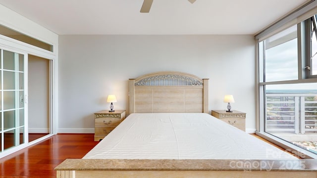 bedroom with a ceiling fan, multiple windows, baseboards, and wood finished floors