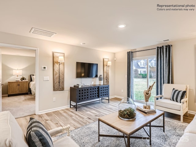 living area featuring light wood finished floors, baseboards, visible vents, and recessed lighting