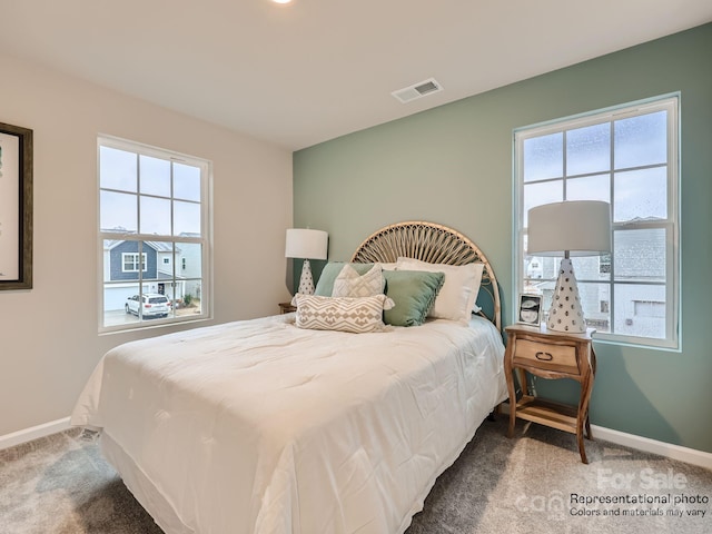 bedroom featuring carpet, visible vents, baseboards, and multiple windows