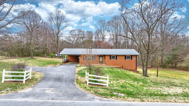 view of front of home with an attached carport, fence, a front lawn, aphalt driveway, and metal roof