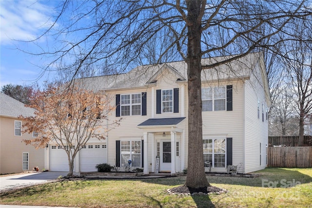 colonial inspired home featuring concrete driveway, a front lawn, and fence