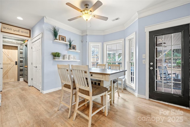 dining area with light wood-style flooring, a ceiling fan, visible vents, baseboards, and ornamental molding