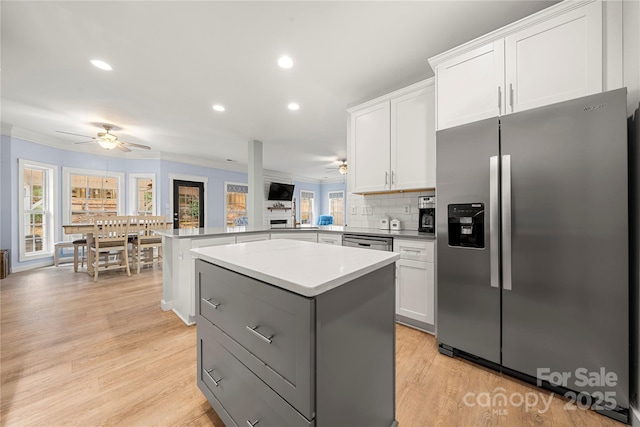 kitchen with stainless steel appliances, a peninsula, a wealth of natural light, and a center island