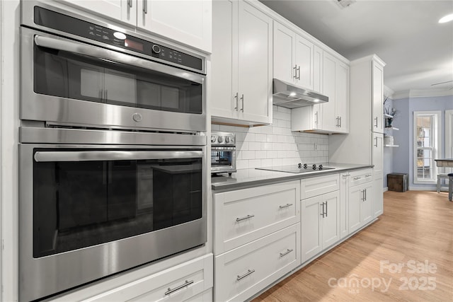 kitchen featuring decorative backsplash, ornamental molding, black electric cooktop, stainless steel double oven, and under cabinet range hood