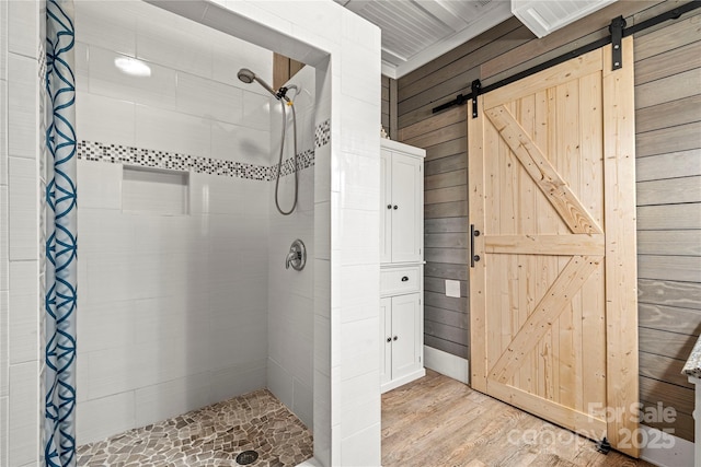 bathroom featuring a stall shower, wooden walls, and wood finished floors