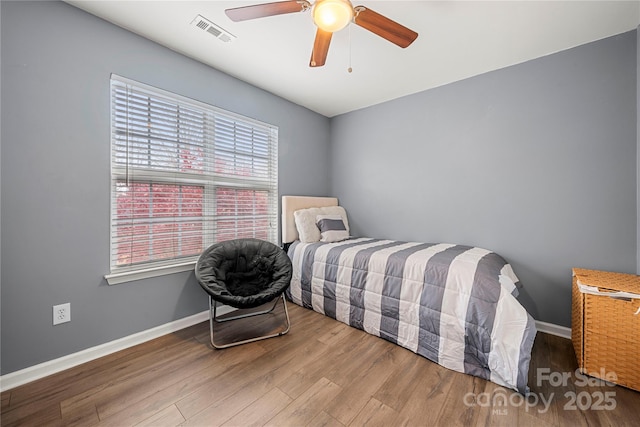 bedroom with ceiling fan, wood finished floors, visible vents, and baseboards