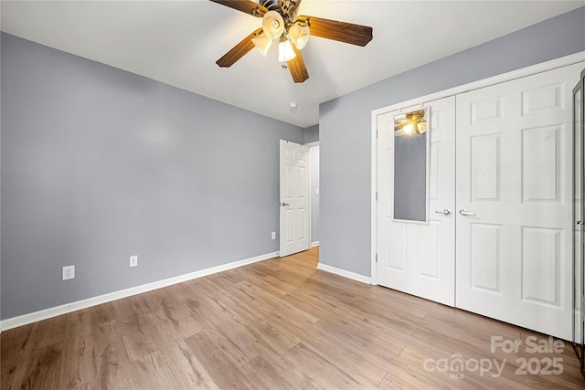 unfurnished bedroom featuring a ceiling fan, a closet, baseboards, and wood finished floors