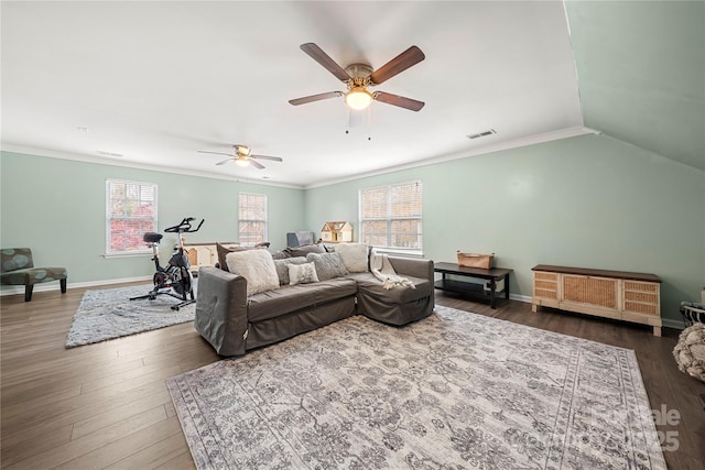 living room featuring baseboards, wood finished floors, visible vents, and crown molding