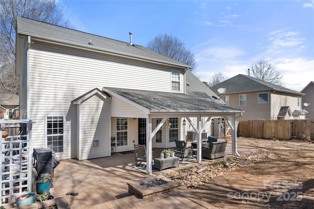 rear view of property with a patio area, a shingled roof, fence, and an outdoor hangout area