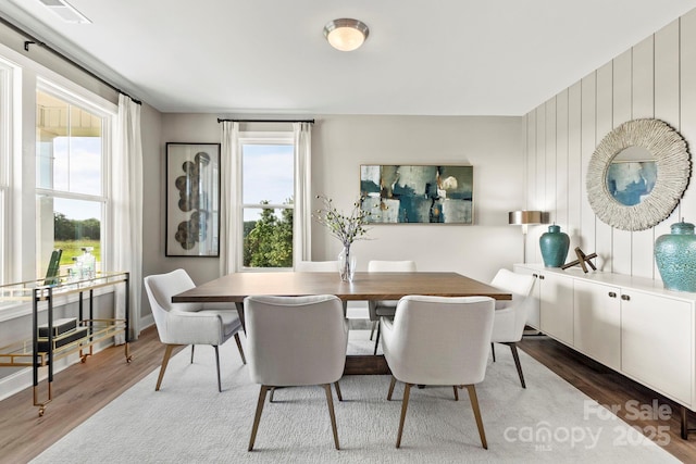 dining room with baseboards, visible vents, and wood finished floors