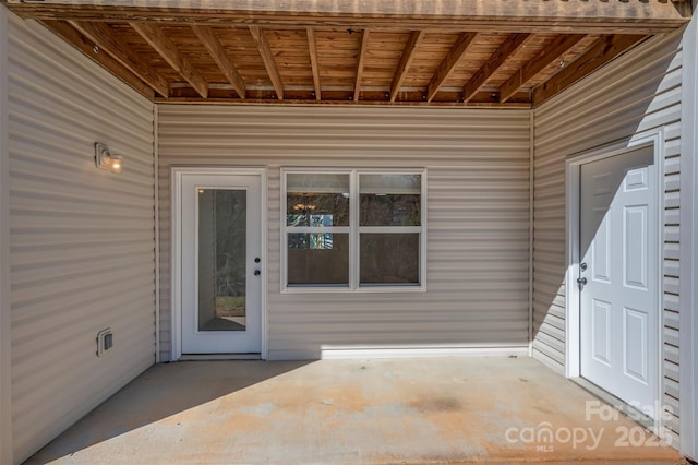 view of exterior entry with a patio