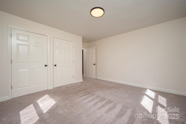 unfurnished bedroom with a closet, baseboards, and carpet flooring