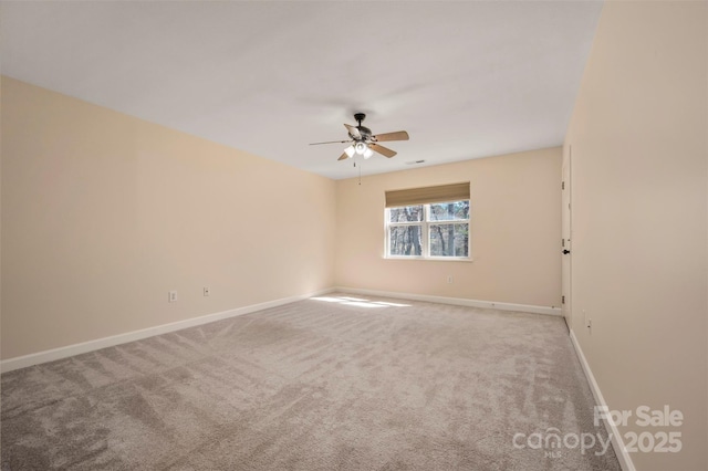 spare room featuring carpet flooring, visible vents, baseboards, and ceiling fan