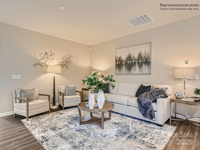 living room featuring baseboards, visible vents, and wood finished floors