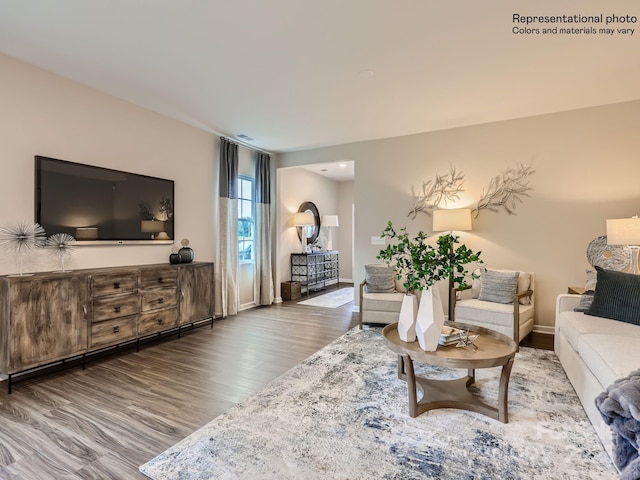 living area featuring wood finished floors, visible vents, and baseboards