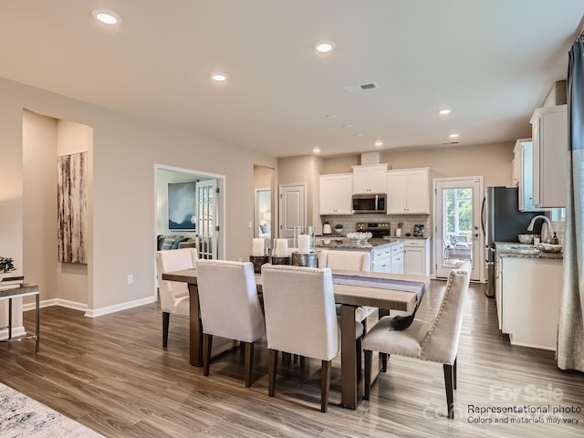 dining room with dark wood-style floors, baseboards, visible vents, and recessed lighting