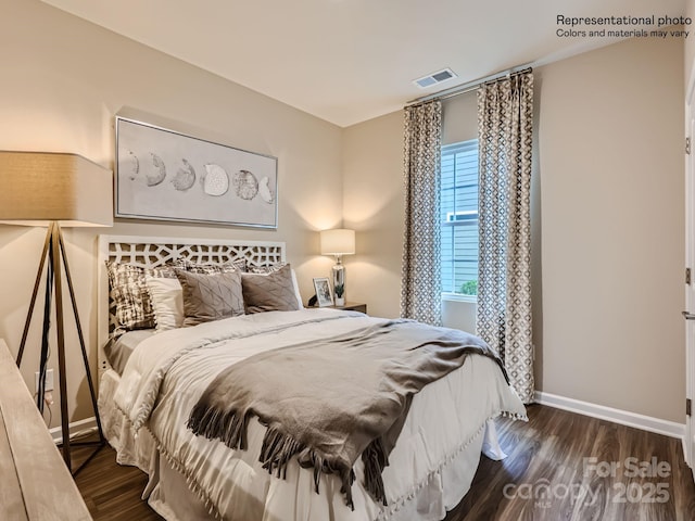 bedroom with visible vents, baseboards, and wood finished floors