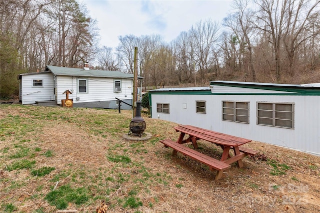 back of house with an outdoor fire pit