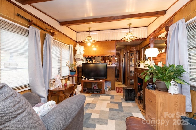 living area with beam ceiling, a chandelier, and a healthy amount of sunlight