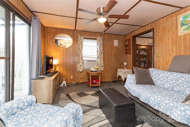 living room featuring carpet floors, wooden walls, and ceiling fan