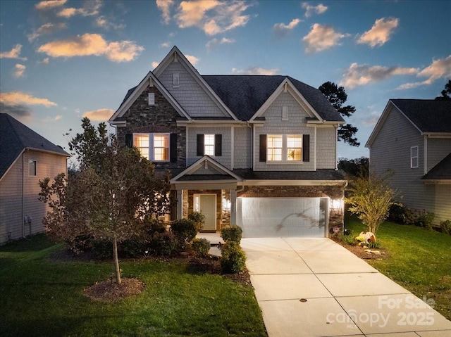 craftsman inspired home with stone siding, a lawn, driveway, and an attached garage