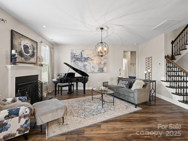 living room featuring stairs, baseboards, and wood finished floors