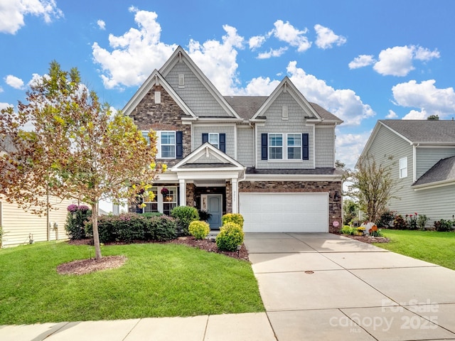 craftsman inspired home with a front lawn, an attached garage, stone siding, and driveway