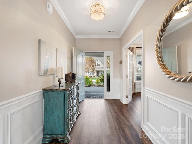 foyer with visible vents, wainscoting, dark wood-type flooring, and ornamental molding