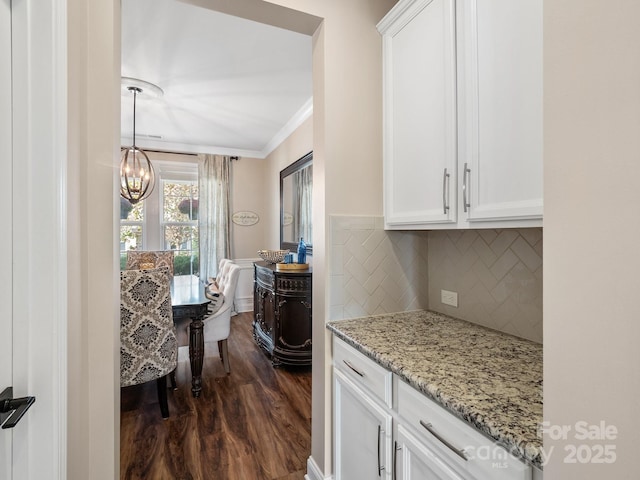 kitchen featuring dark wood finished floors, a notable chandelier, white cabinets, and crown molding