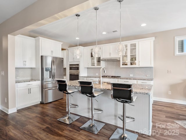 kitchen with tasteful backsplash, white cabinetry, appliances with stainless steel finishes, glass insert cabinets, and dark wood-style flooring