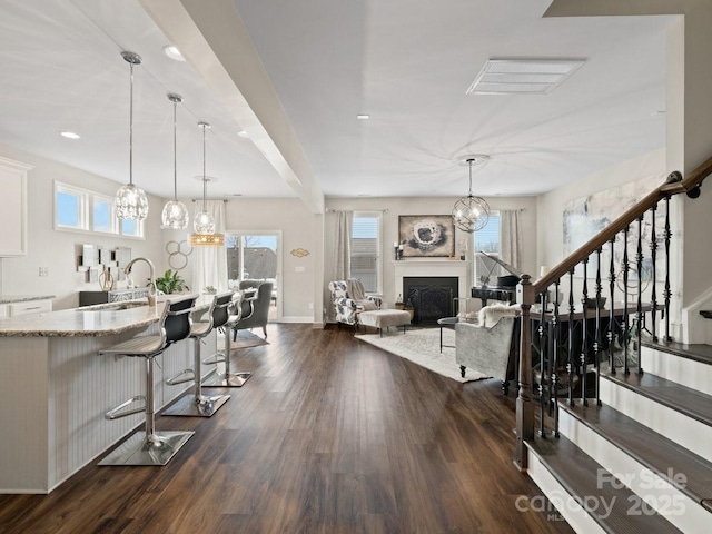 interior space with a chandelier, dark wood-style floors, a fireplace, and baseboards