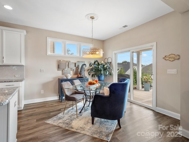 dining room featuring visible vents, baseboards, a notable chandelier, and dark wood-style flooring