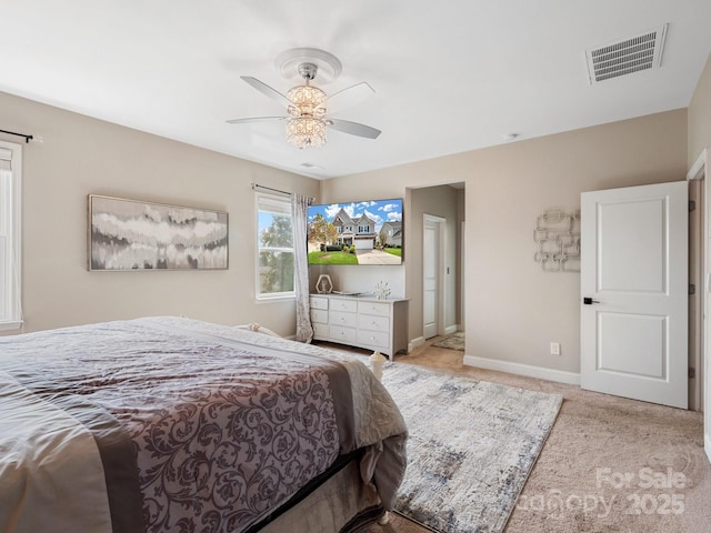 bedroom featuring visible vents, light colored carpet, a ceiling fan, and baseboards