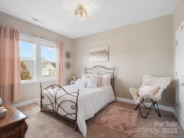 bedroom with visible vents, light colored carpet, and baseboards