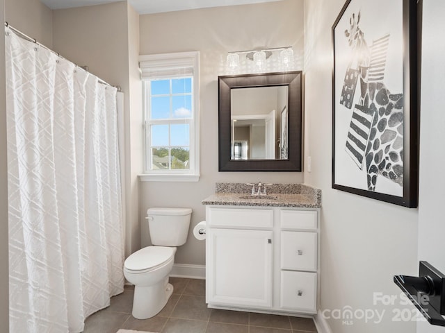 bathroom featuring tile patterned flooring, toilet, vanity, and baseboards