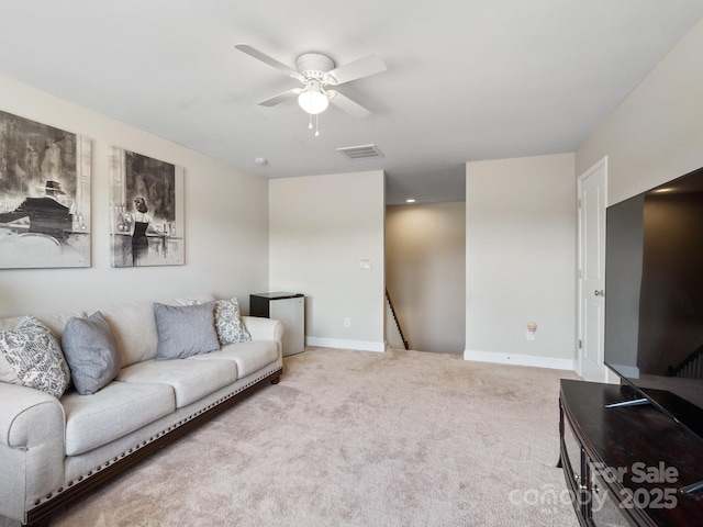 living area with baseboards, visible vents, carpet floors, and ceiling fan