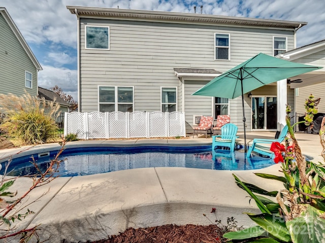 pool with a patio area and fence