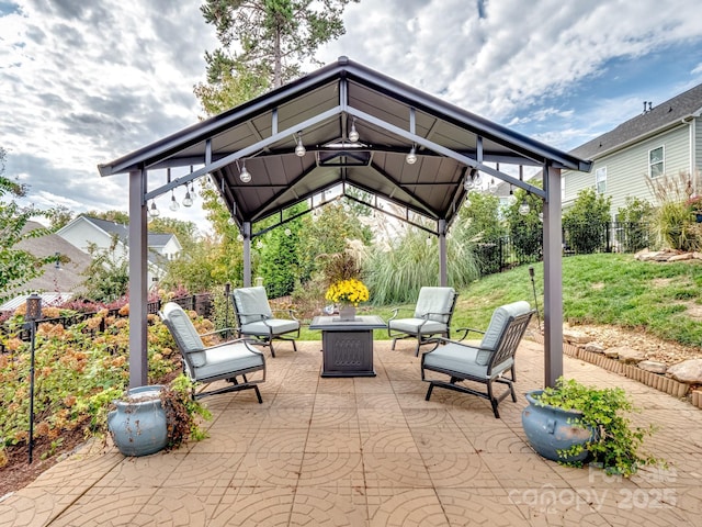 view of patio / terrace with a gazebo, fence, and a fire pit