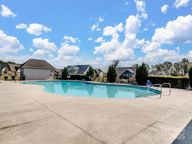 community pool featuring a patio and fence